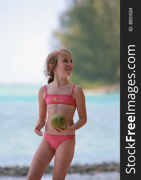 Girl playing with a coconut on the beach. Girl playing with a coconut on the beach