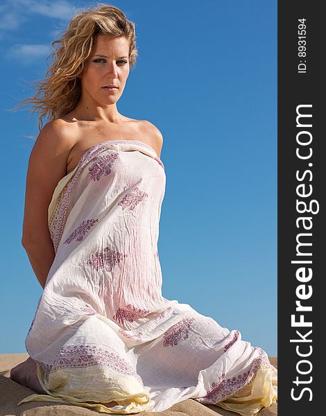 Young beautiful woman with white dress on the beach