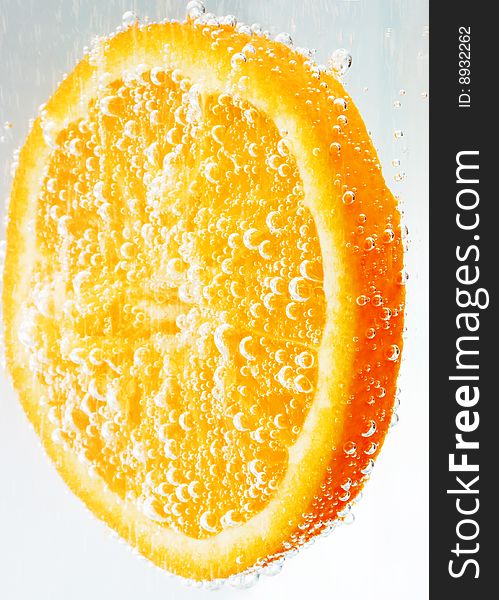 An orange slice covered with and surrounded by bubbles. An orange slice covered with and surrounded by bubbles.