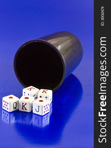 Tumbler with dices in poker on blue background