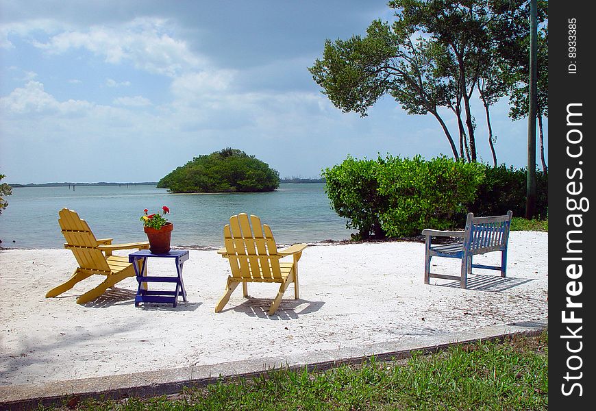 A personal beach set up with chairs and a bench.