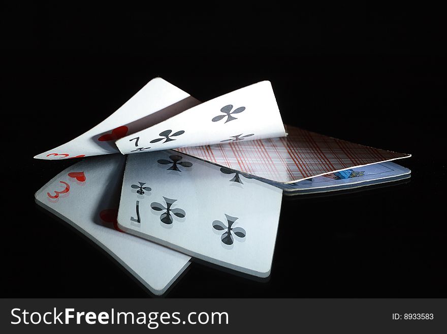 Two opened cards and one closed playing card on dark background. Two opened cards and one closed playing card on dark background