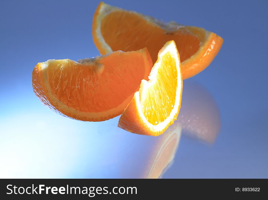 Sliced orange with reverberation on blue background