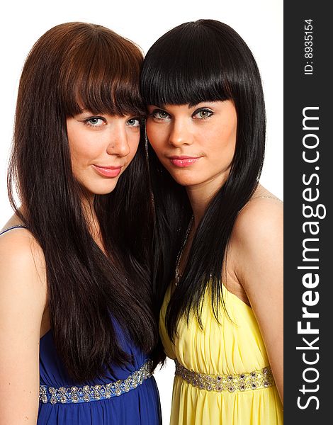 Two brunette woman in same  blue and yellow dresses. Two brunette woman in same  blue and yellow dresses