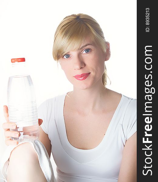 The girl of a sports kind with a bottle of water in a hand. The girl of a sports kind with a bottle of water in a hand