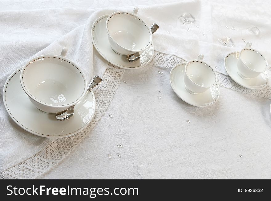 Four teacups on a table with tablecloth