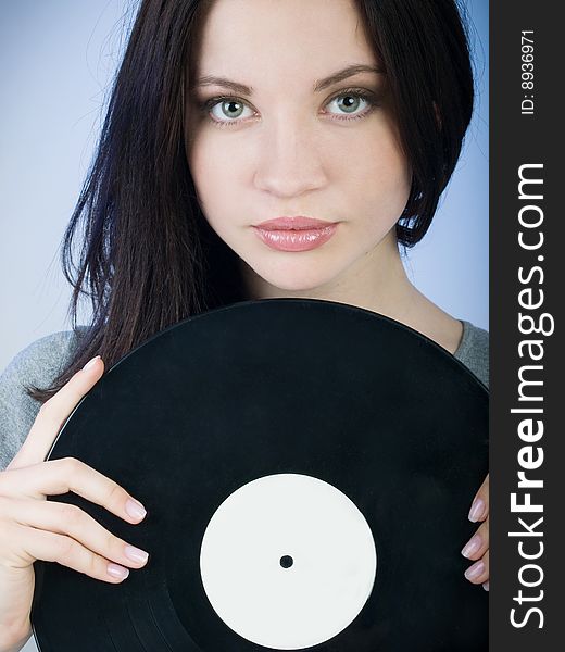 Beautiful girl holding a vinyl record in front of her. Beautiful girl holding a vinyl record in front of her