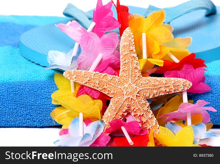 Starfish, lei and flip flops on a beach towel. Starfish, lei and flip flops on a beach towel