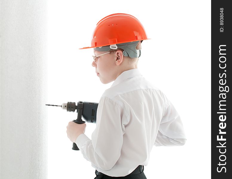 Teenager in protective helmet and spectacles drill the wall. Teenager in protective helmet and spectacles drill the wall