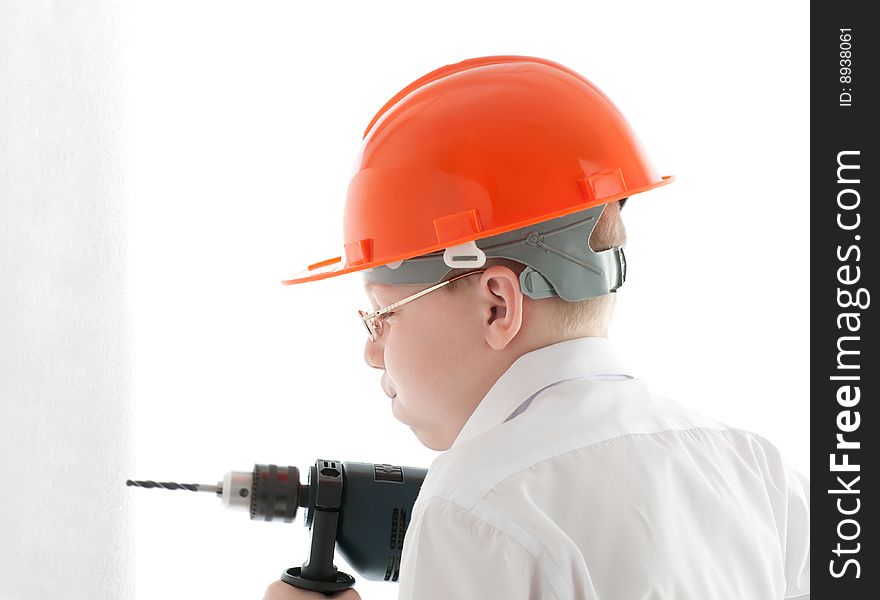 Teenager in protective helmet and spectacles drill the wall. Teenager in protective helmet and spectacles drill the wall