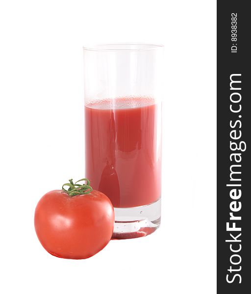 Glass with juice and a tomato of red color