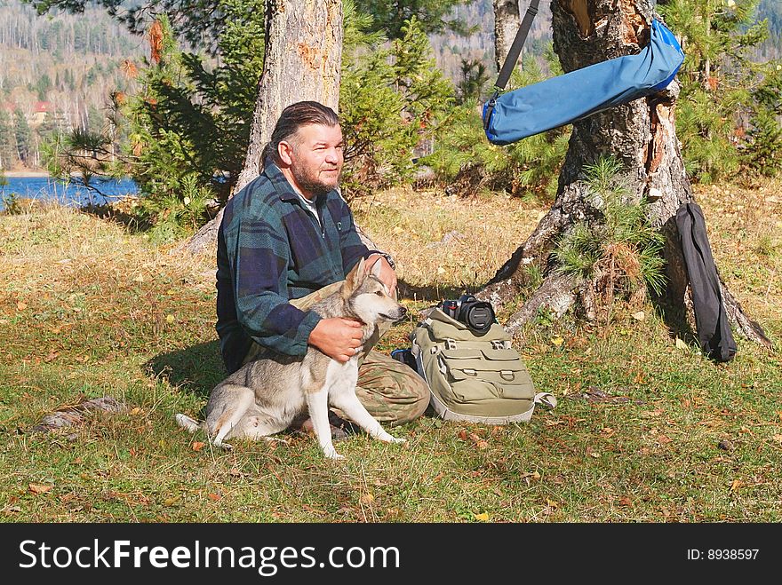 Old men and his hunting dog sitting in nature. Old men and his hunting dog sitting in nature