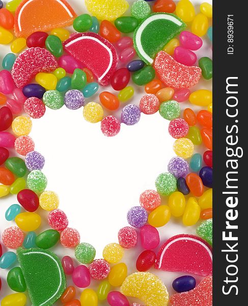 A colorful background of assorted gummy candies, with a heart shape in the middle with white copy space. A colorful background of assorted gummy candies, with a heart shape in the middle with white copy space