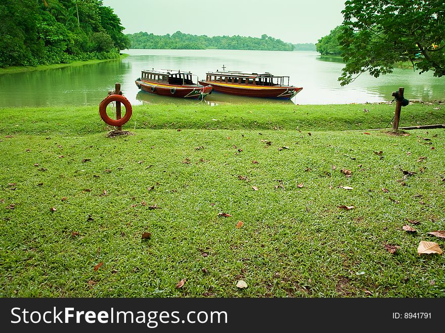 Lakeside with boats parking in green background. Lakeside with boats parking in green background