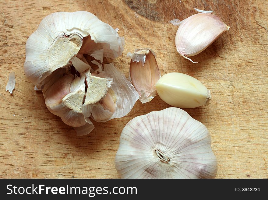 Two heads of garlic lying on wooden background