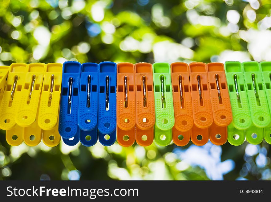 Clothespins on clothesline against green background