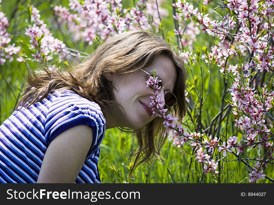 Young beautiful girl smelling flowers;beautiful spring day. Young beautiful girl smelling flowers;beautiful spring day