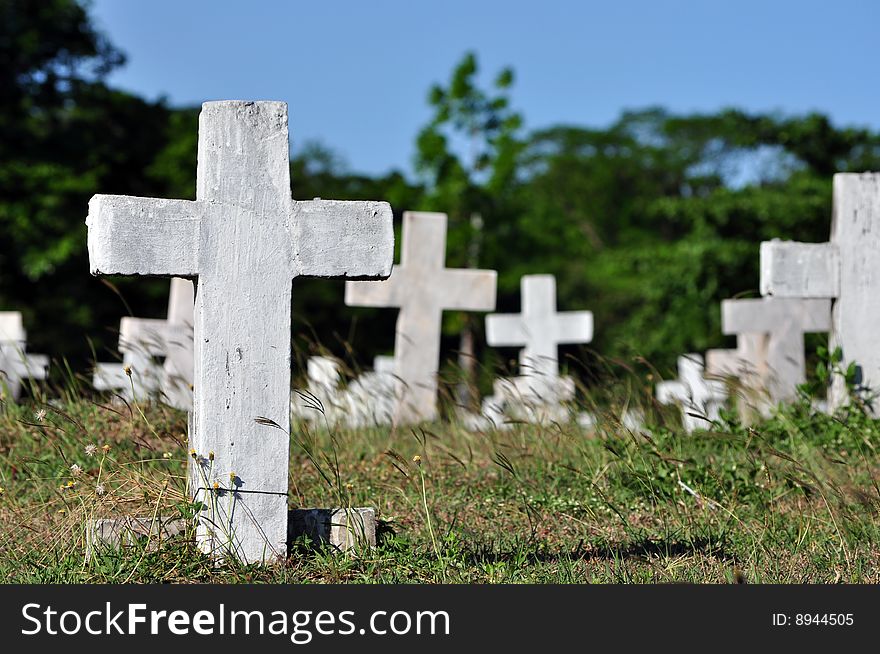 Cement tombstone crosses, towering the wild grass in the cemetery. Cement tombstone crosses, towering the wild grass in the cemetery.