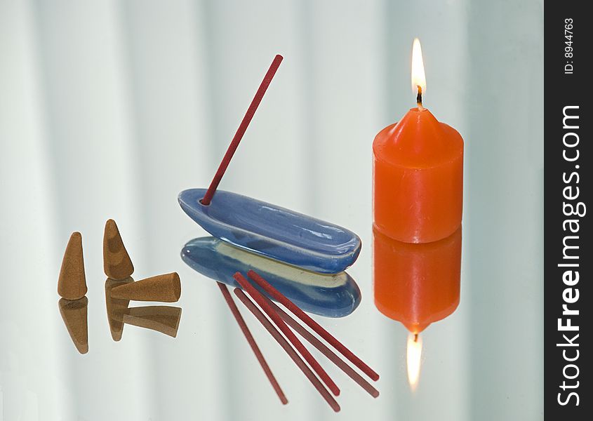 The flavored sticks, the support, burning candle on a mirror. The flavored sticks, the support, burning candle on a mirror