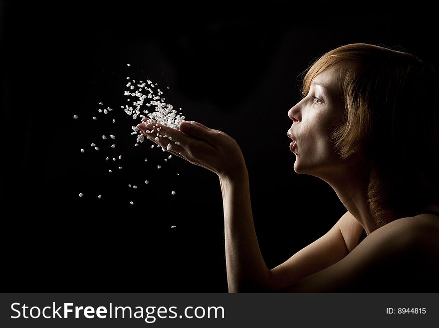 Beautiful woman blowing white fluff. Beautiful woman blowing white fluff