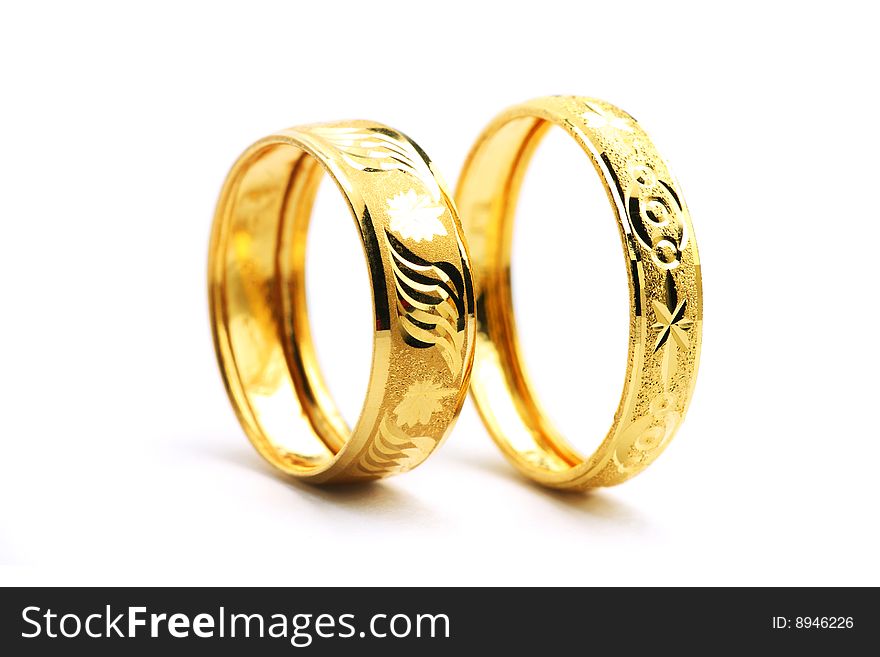 Two golden rings standing on white background.