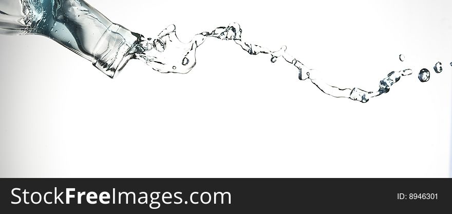 Bottle and creative splashing water.Isolated on white