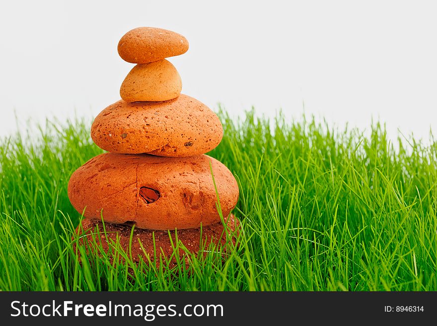 Pyramid of red cobble-stones in the green grass. Pyramid of red cobble-stones in the green grass