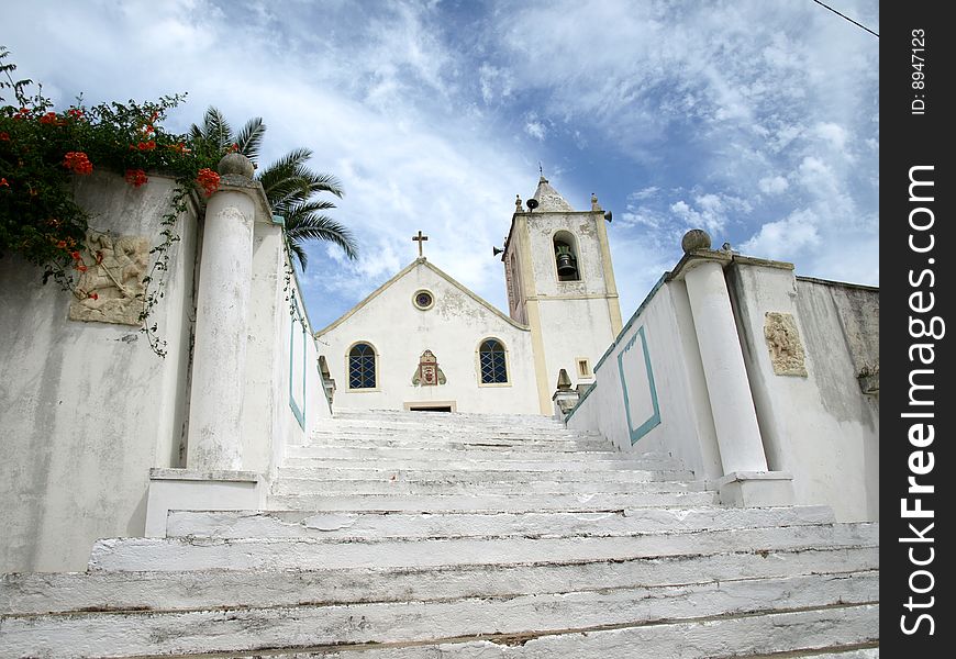 Small village church in Portugal, stairs and a palm above. Small village church in Portugal, stairs and a palm above
