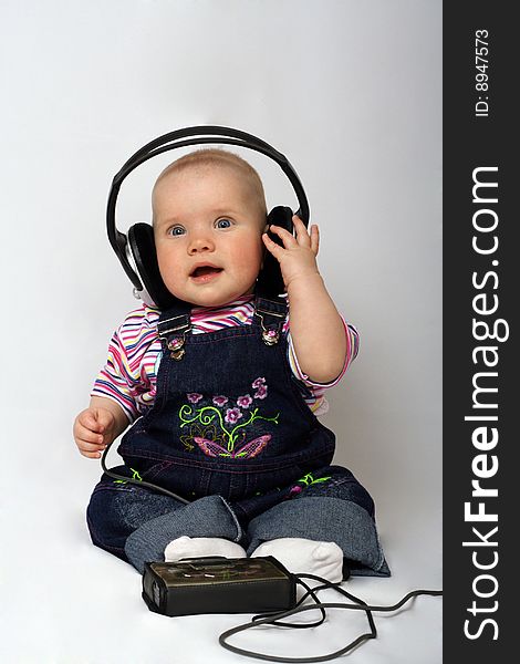 Little girl listen music in big headphones