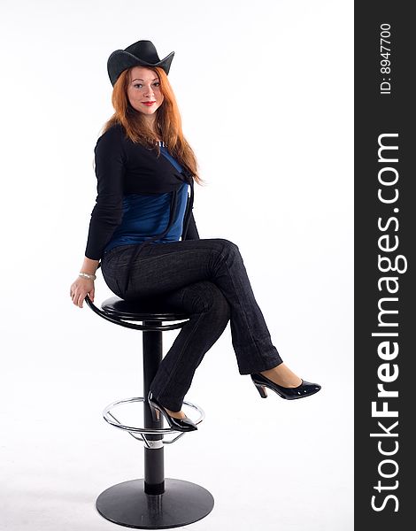 Young girl with  black hat sitting on chair on white background. Young girl with  black hat sitting on chair on white background