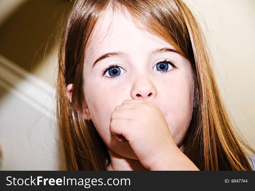 A cute young girl with her thumb in her mouth. A cute young girl with her thumb in her mouth.