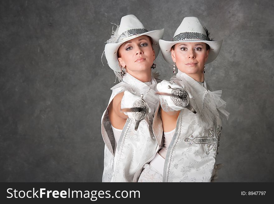 Beautiful girls in suits of musketeers