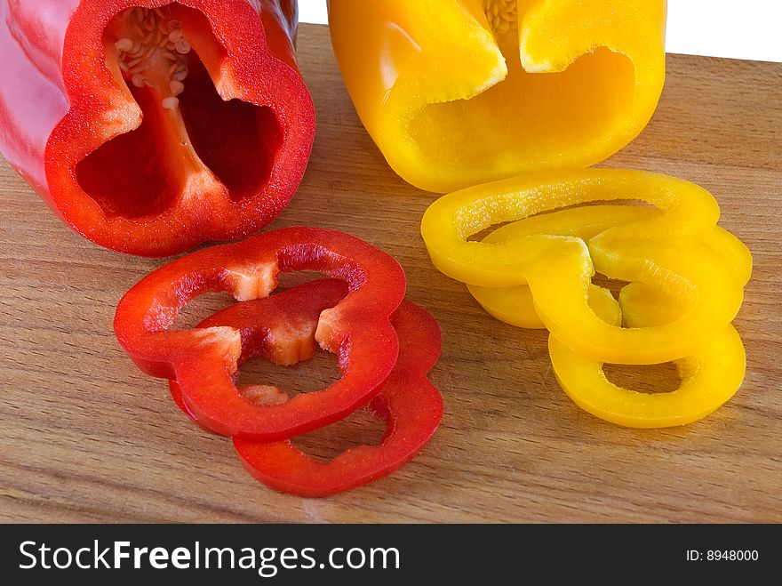 Red and yellow sweet pepper lays on a chopping board. Red and yellow sweet pepper lays on a chopping board