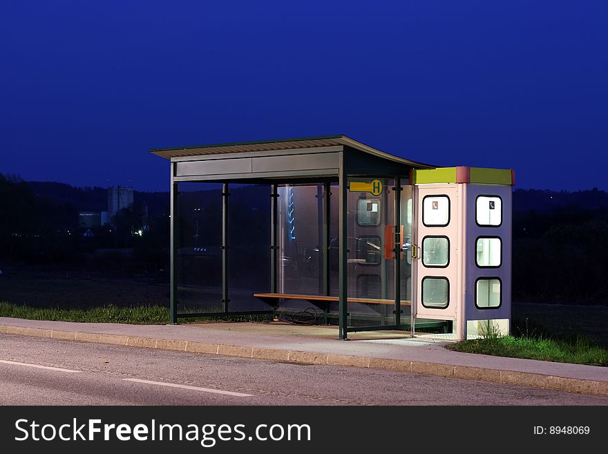 Bus stop with telephone booth at dusk. Bus stop with telephone booth at dusk