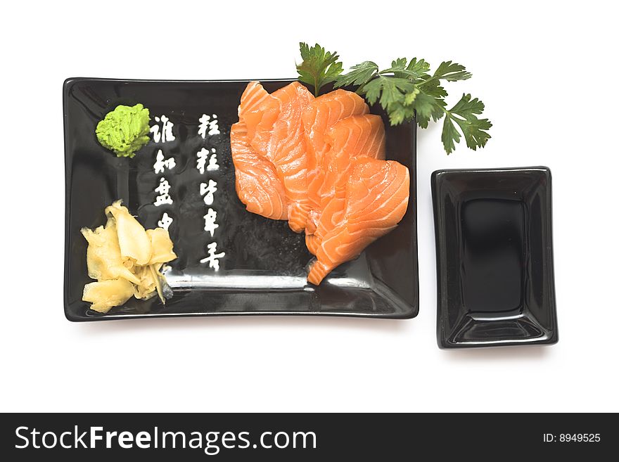 A set of sushi on a black plate with wasabi and gari, isolated on a white background. A set of sushi on a black plate with wasabi and gari, isolated on a white background.