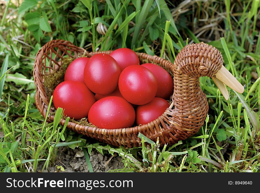 Red easter eggs in duck shaped basket