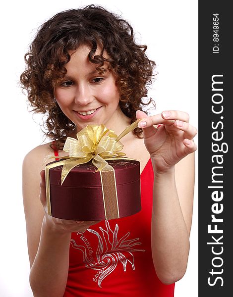 Beautiful woman with a gift. Attractive girl holding purple box with gold ribbon. Woman is surprising at present. Isolated over white background. Beautiful woman with a gift. Attractive girl holding purple box with gold ribbon. Woman is surprising at present. Isolated over white background.