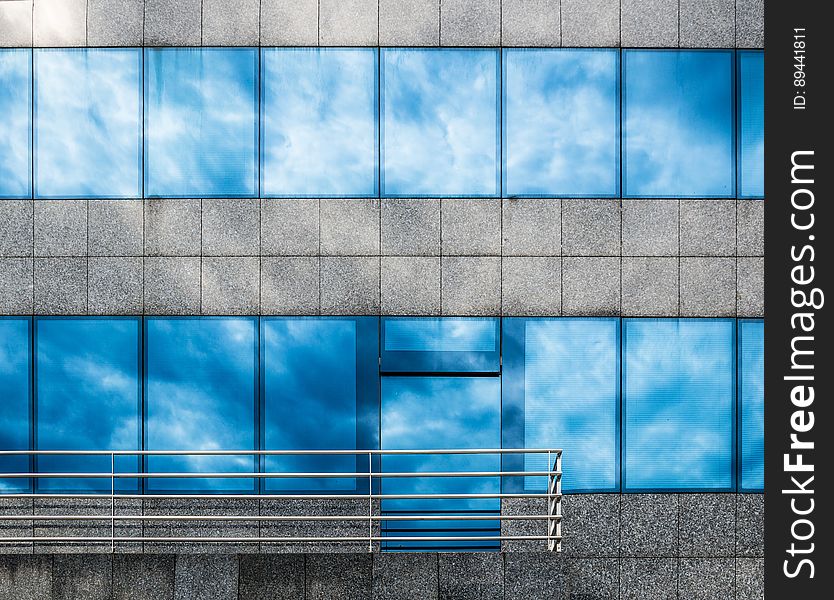 The exterior of a building with sky reflecting from the windows. The exterior of a building with sky reflecting from the windows.