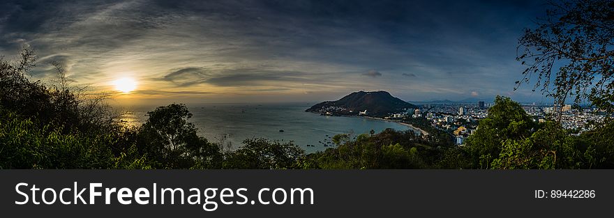 A panorama over a city and cape in the sea at sunset. A panorama over a city and cape in the sea at sunset.
