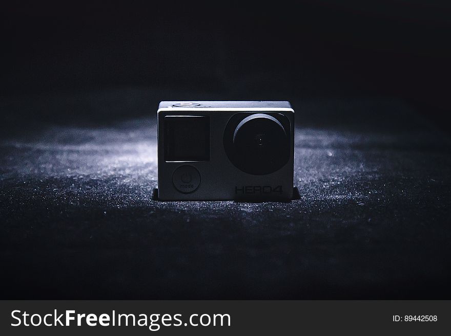 Close up of small GoPro camera on black fabric in shadows. Close up of small GoPro camera on black fabric in shadows.
