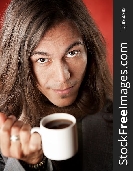 Closeup Portrait of a Handsome Young Man with Long Hair Drinking Coffee. Closeup Portrait of a Handsome Young Man with Long Hair Drinking Coffee