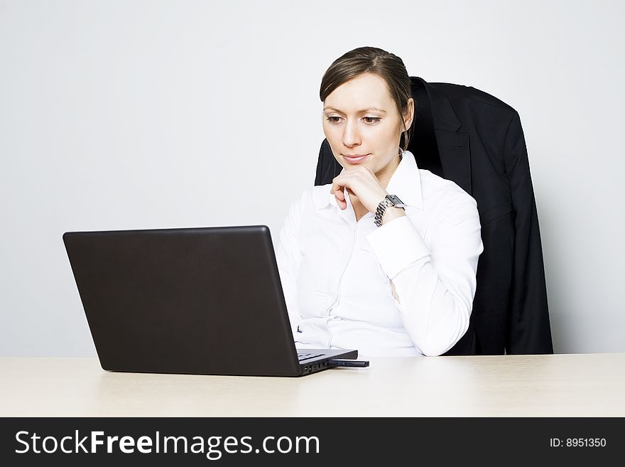 Young businesswoman in front of her computer on white background. Young businesswoman in front of her computer on white background