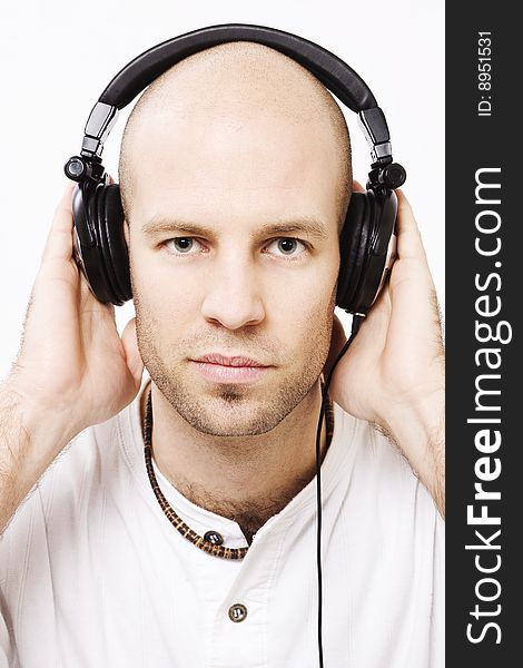 Young man wearing headphones - with hands on the headphones. Young man wearing headphones - with hands on the headphones