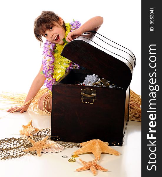 An elementary girl dressed in a Hawaiian grass skirt and leis, surprised when she opens a treasure trunk full of jewels.  Isolated on white. An elementary girl dressed in a Hawaiian grass skirt and leis, surprised when she opens a treasure trunk full of jewels.  Isolated on white.