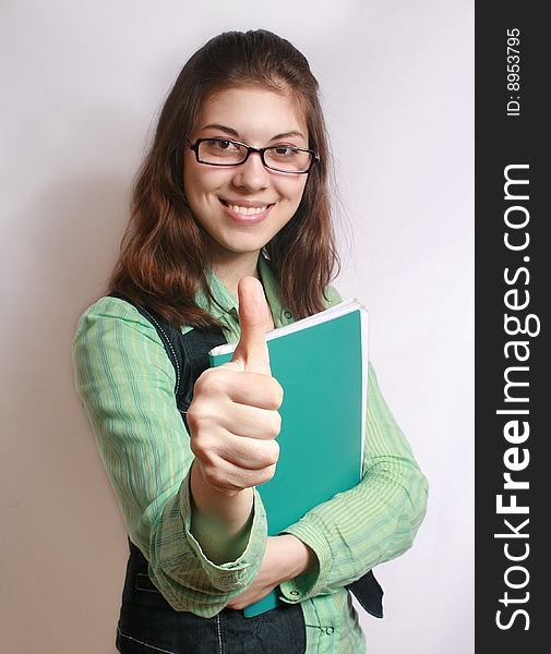 The image of the girl with the hand extended forward and lifted upwards thumb. The image of the girl with the hand extended forward and lifted upwards thumb.