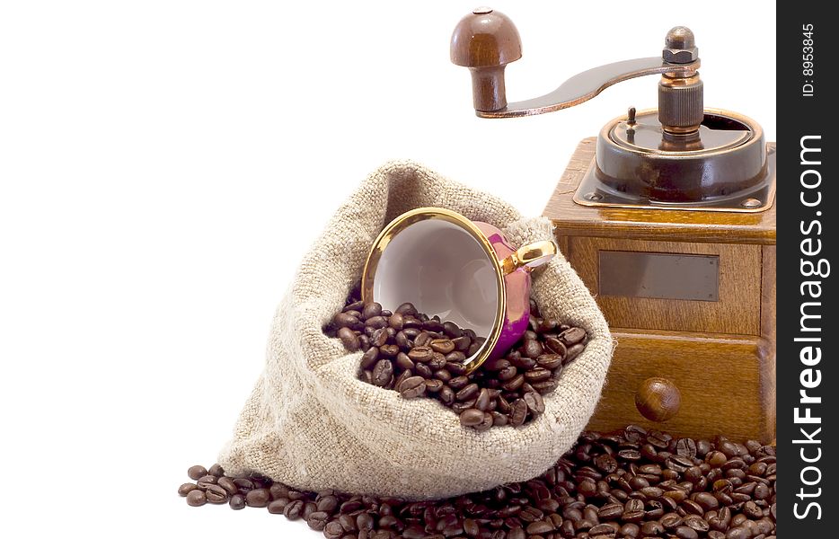 Coffee grinder, cup lies in sack with coffee grains is isolated on white