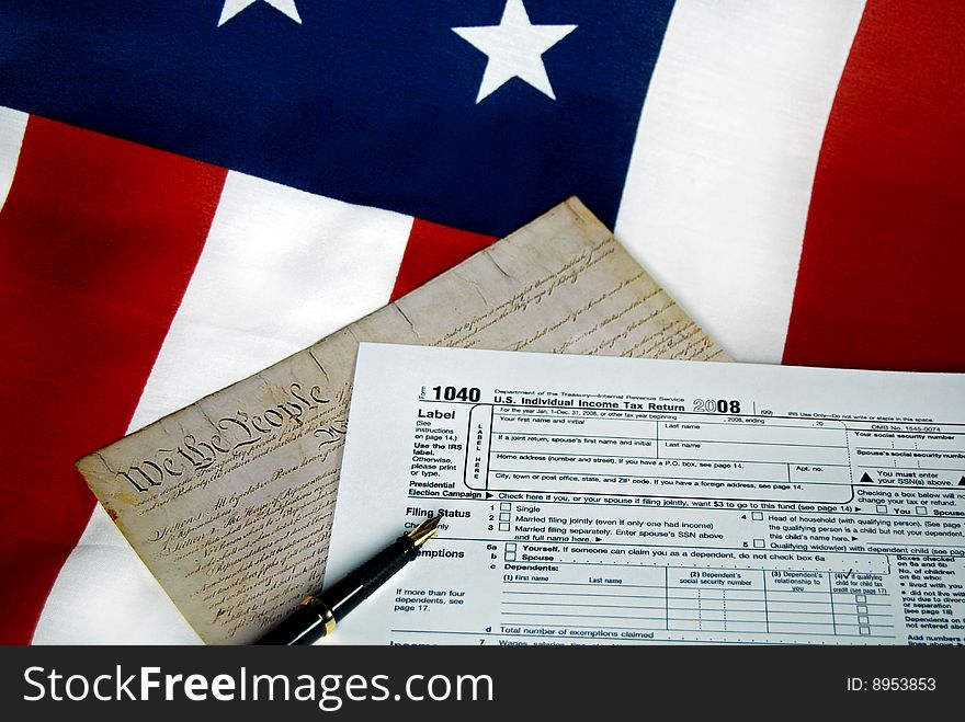 The U.S. Constitution and tax form on an American flag. The U.S. Constitution and tax form on an American flag.