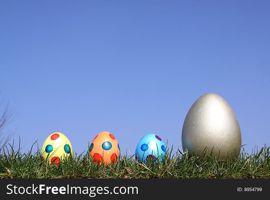 Easter eggs in grass against  a bright blue sky