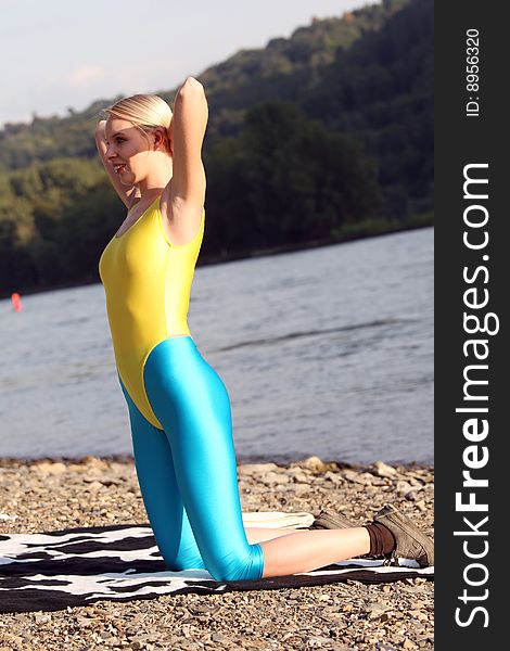 Woman doing fitness exercises on the shore. Woman doing fitness exercises on the shore