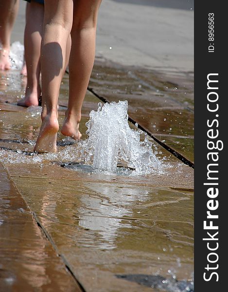 Naked feet running through a fountain. Naked feet running through a fountain